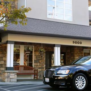 A storefront with a stone facade and a car parked in front.