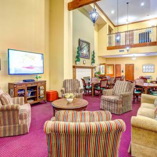 A cozy and spacious living room featuring comfortable seating, a large television, and warm decor.