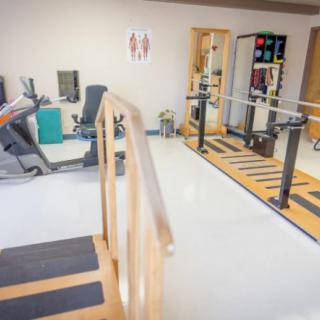 A physical therapy room equipped with various rehabilitation and exercise machines.