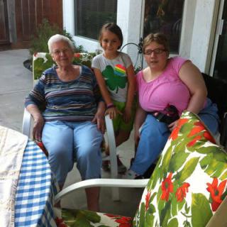 A group of three people enjoying time together on a patio.