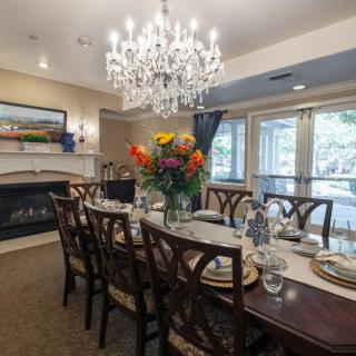Elegant dining room with a chandelier, set for dinner.