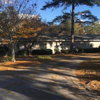 A peaceful residential setting featuring a house surrounded by autumn foliage.