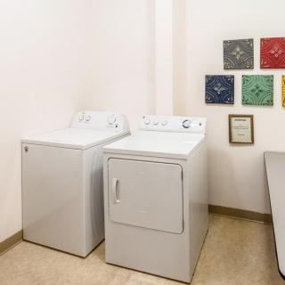 A laundry room featuring a washing machine and dryer with artwork on the wall.