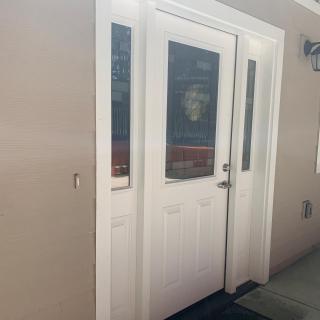 A white exterior door with glass panels leading into a building.