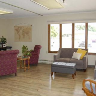 A cozy living room with various seating options and a map on the wall.