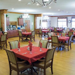 A spacious and elegantly set dining area with neatly arranged tables and chairs.