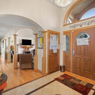 A spacious and elegantly designed hallway featuring wooden doors and arched ceilings, enhancing the warmth of the interior.