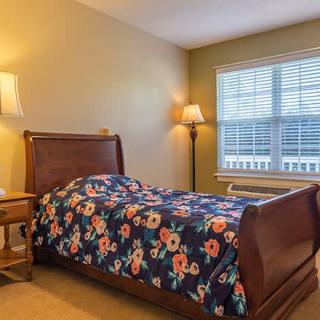 A cozy bedroom with a floral bedspread and warm lighting.