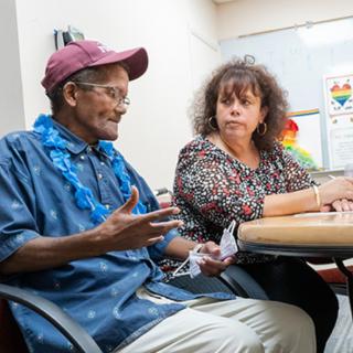 Two people engaged in a conversation during a meeting.