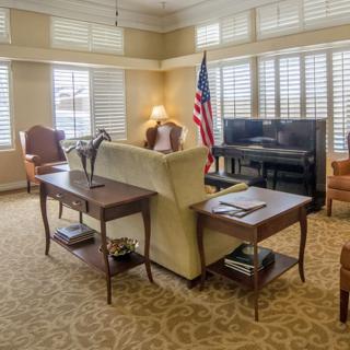 A well-furnished office space with a sofa, desk, and American flag.
