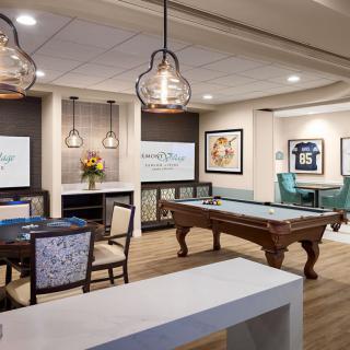 A modern game room featuring a pool table, stylish seating, and contemporary lighting.