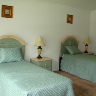 A bedroom featuring two twin beds with matching bedding and bedside lamps.