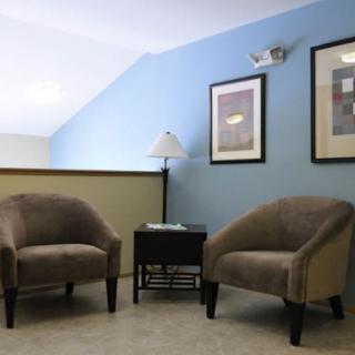 A cozy interior setup with two armchairs, a side table, and wall art.