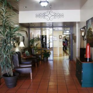 A cozy lobby with seating and plants, leading to an interior hallway.