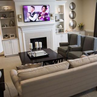 A cozy living room with a fireplace, sofa, and television.