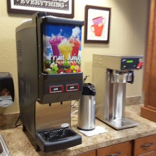 A beverage station featuring a soda fountain and a coffee machine.