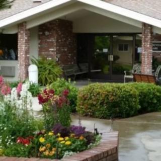 A beautifully landscaped garden in front of a brick building.