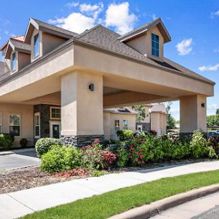 A beautifully designed building with well-kept landscaping under a clear blue sky.
