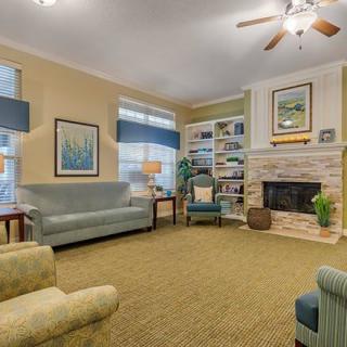 A cozy living room with comfortable seating, a fireplace, and a well-organized bookshelf.
