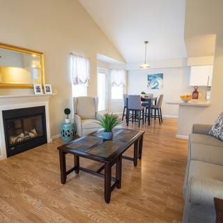 A cozy living room with hardwood floors, featuring a fireplace and an adjacent dining area.