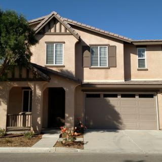 A suburban two-story house with a garage and driveway.