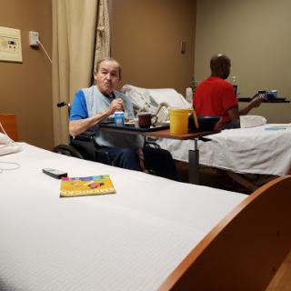 Patients in a hospital room sharing a meal.
