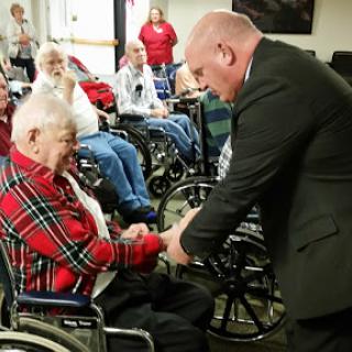 A meaningful interaction between a caregiver and an elderly resident during a community event.