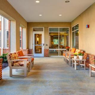 A cozy outdoor patio with wooden benches and colorful cushions.