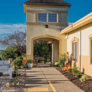 A building entrance with a landscaped pathway under a clear blue sky.