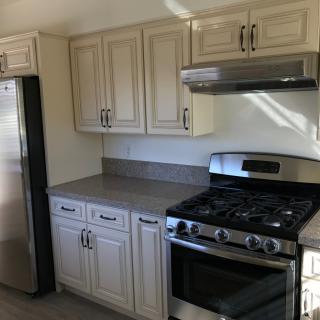 Modern kitchen with stainless steel appliances and light-colored cabinets.