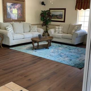 A cozy living room with two sofas, a coffee table, and a decorative rug on wooden flooring.