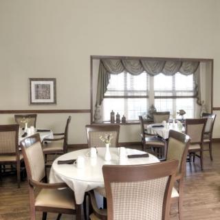 A cozy dining room with elegantly set tables and chairs.