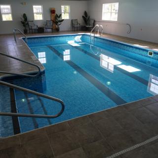 An indoor swimming pool with clear water and surrounding tiles.