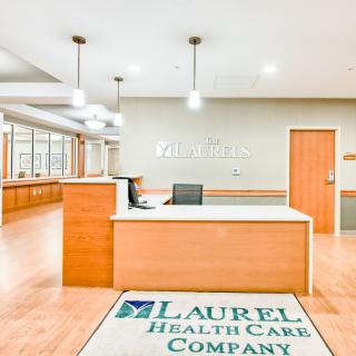 A modern healthcare reception area with a wooden desk and bright lighting.