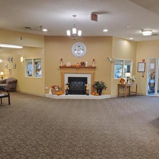 A spacious lobby featuring a central fireplace, surrounded by comfortable decor and furnishings.