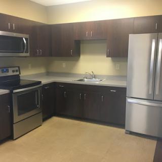 A modern kitchen featuring stainless steel appliances and dark wood cabinets.