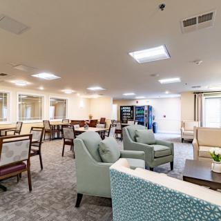 A spacious and bright lounge area with comfortable seating and tables.