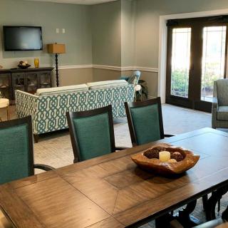 A stylish and modern open-concept living and dining area featuring a wooden table with chairs, a patterned sofa, and a television.