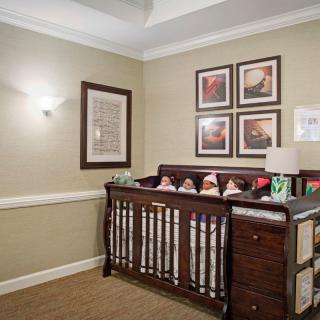 A cozy nursery featuring a wooden crib and decorative wall art.