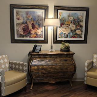 A cozy living room setup featuring elegant artwork, a stylish lamp, and comfortable seating.