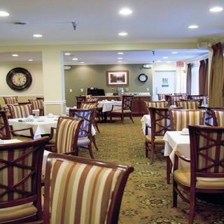 An elegantly furnished dining room with neatly arranged tables and chairs.