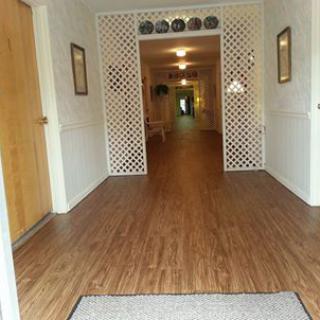 A well-lit hallway showcasing a warm wooden floor and decorative elements.