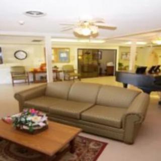A cozy living room with a sofa, coffee table, and ceiling fan.