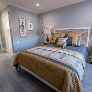 A modern bedroom with a stylish bed, cozy decor, and contemporary artwork on the walls.