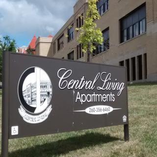 Sign for Central Living Apartments in front of a building.