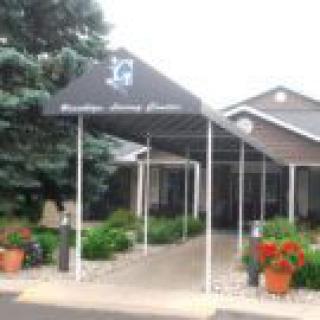 Entrance with an awning and potted plants.