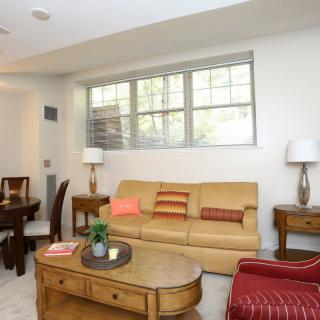 A cozy living room with a beige sofa, wooden coffee table, and ambient lighting.