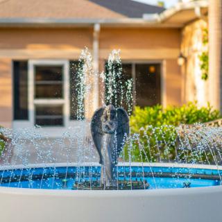 A decorative elephant fountain in a garden setting.