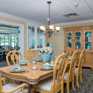 A well-appointed dining room with a wooden table, elegant place settings, and a decorative china cabinet.