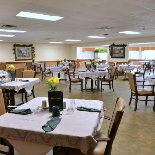 An elegantly set dining area with neatly arranged tables and chairs, ready for guests.